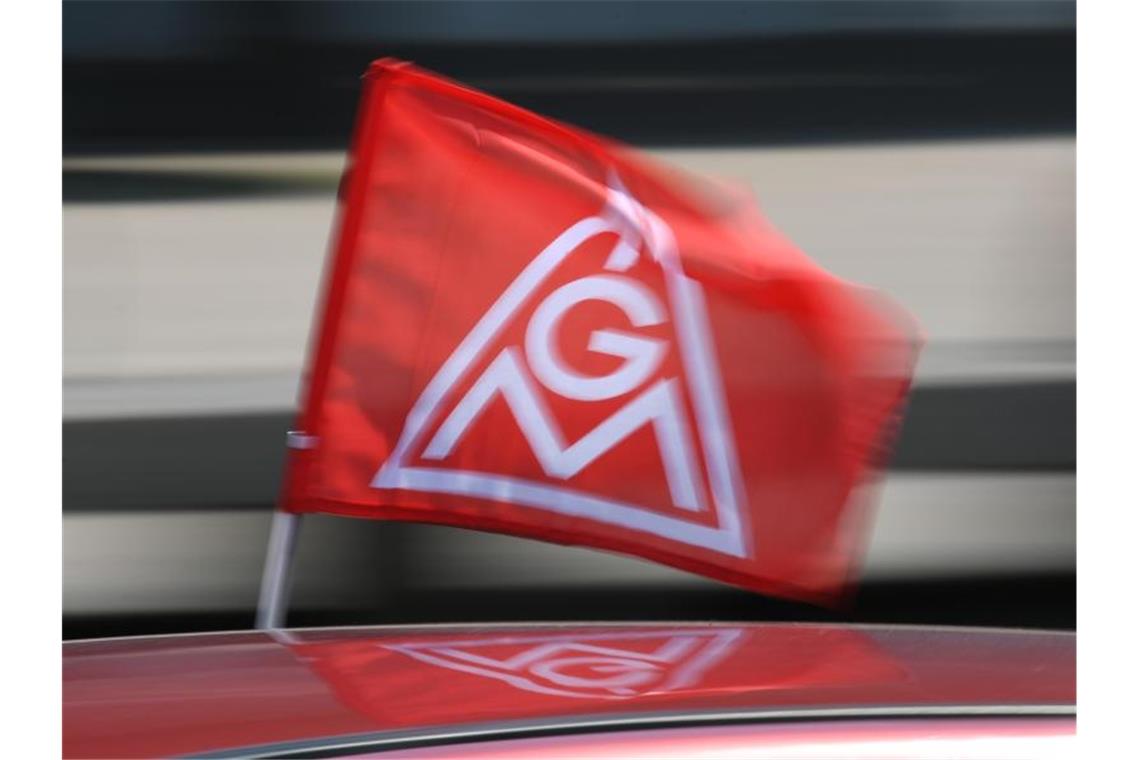 Warnstreik mit Autokorso in Freiburg Eine rote IG-Metall-Flagge spiegelt sich in einem Fahrzeugdach. Foto: Patrick Seeger