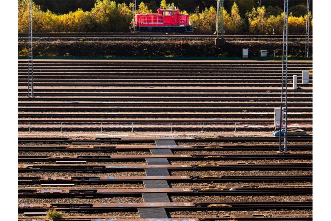 Eine rote Rangierlokomotiven fährt im Nordwesten der bayerischen Landeshauptstadt an den leeren Schienen eines Rangierbahnhof der Deutschen Bahn (DB) vorbei. Foto: Peter Kneffel/dpa