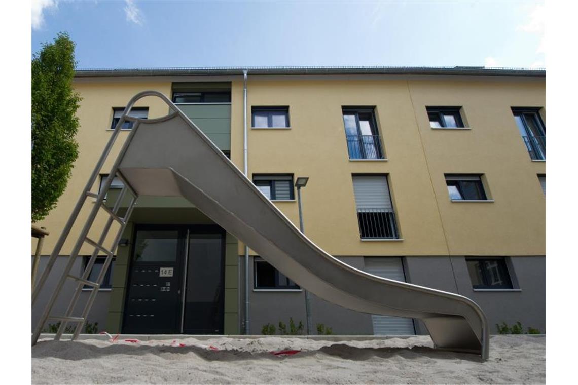 Eine Rutsche steht vor einem Gebäude mit neugebauten Sozialwohnungen. Foto: Marijan Murat/Archivbild