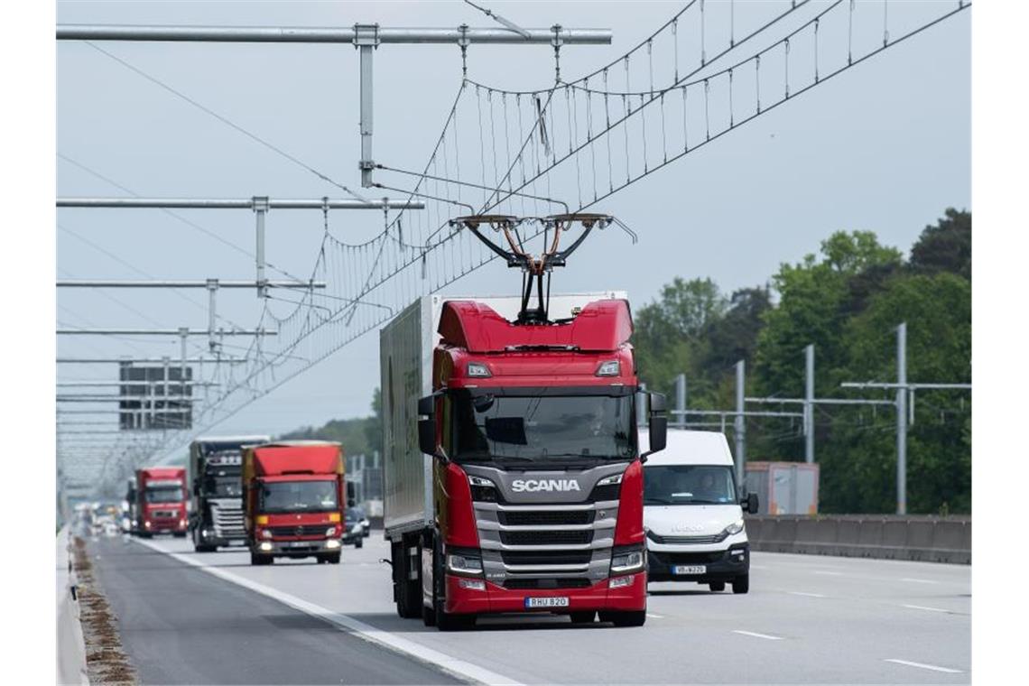 Eine Scania R450 Hybrid Zugmaschine (M) fährt während der Inbetriebnahme der ersten deutschen Teststrecke für E-Lastwagen mit Oberleitung auf der Autobahn 5. Foto: Silas Stein