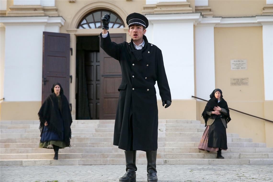 Ungarische Gäste in Backnang mit schwerem Gepäck Eine Schlüsselszene im Theaterstück „Schweres Gepäck“: Der Büttel verkündet die Vertreibung vor der Kirche. Foto: Dénes Mártonfai