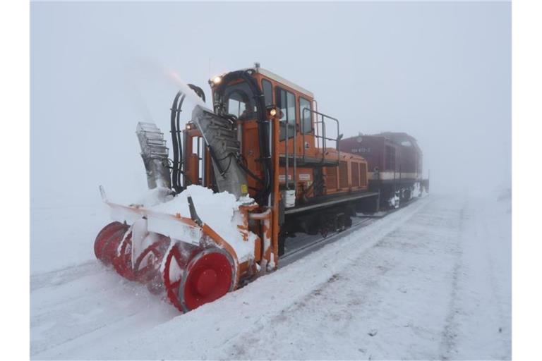 Eine Schneefräse der Harzer Schmalspurbahn räumt bei nebligem Wetter den Schnee aus den Gleisen auf dem Brocken. Foto: Matthias Bein/dpa-Zentralbild/dpa