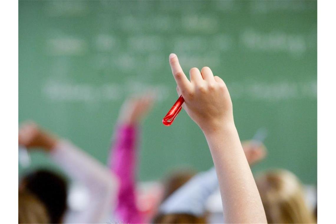 Eine Schülerin meldet in einem Klassenzimmer. Foto: picture alliance / Marijan Murat/dpa/Archivbild