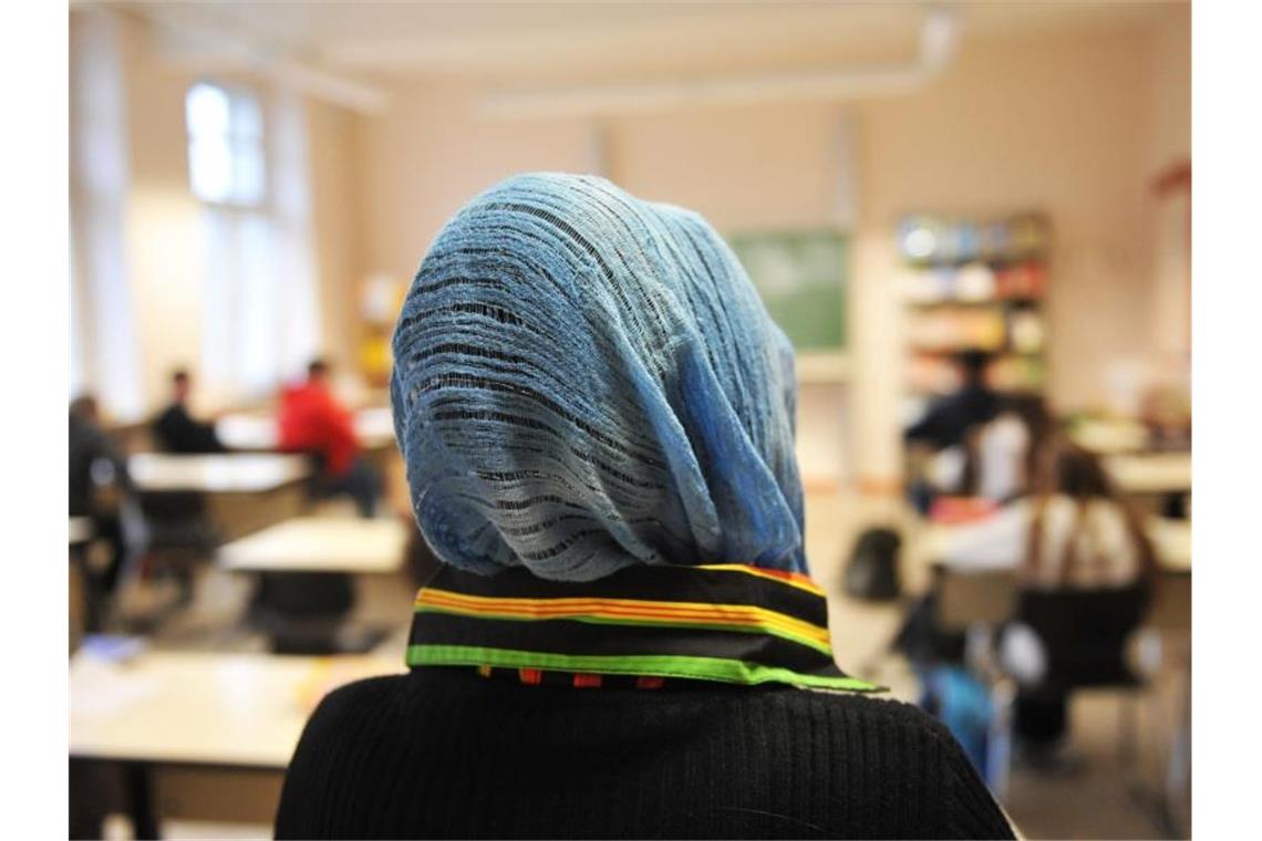 Eine Schülerin mit Kopftuch nimmt am Unterricht teil. Foto: Bernd Thissen/dpa