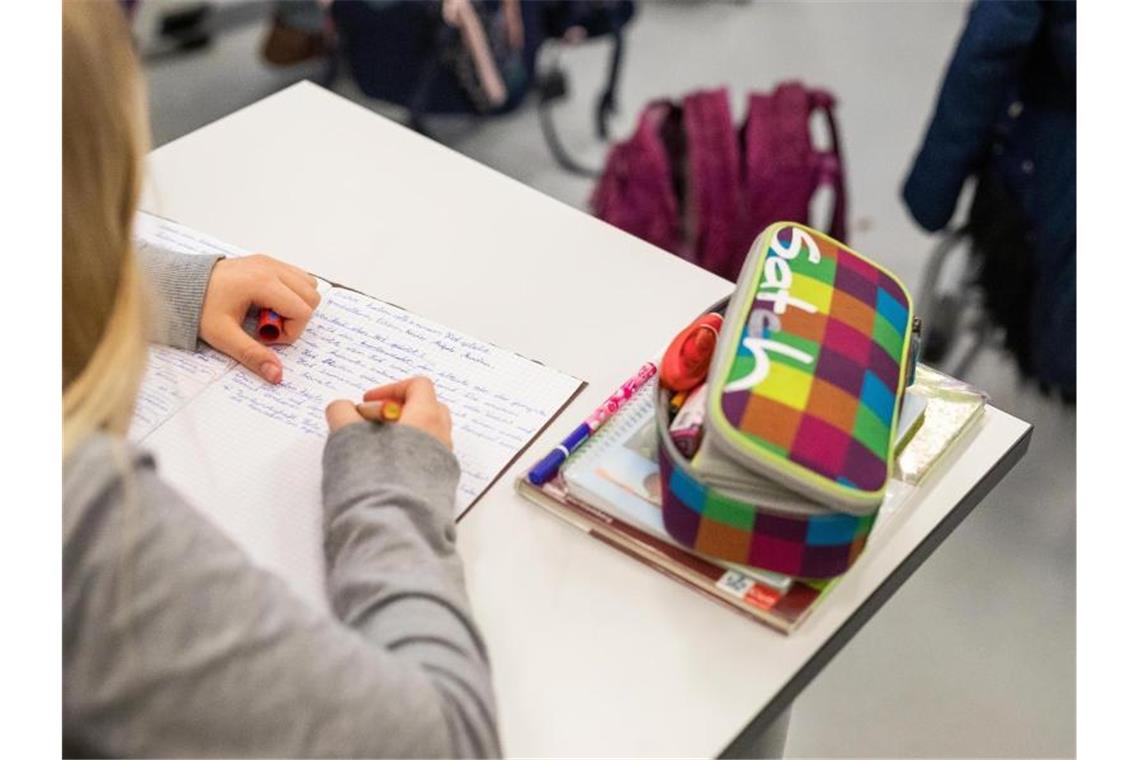 Eine Schülerin sitzt in ihrem Klassenzimmer und schreibt. Foto: Philipp von Ditfurth/dpa/Symbolbild