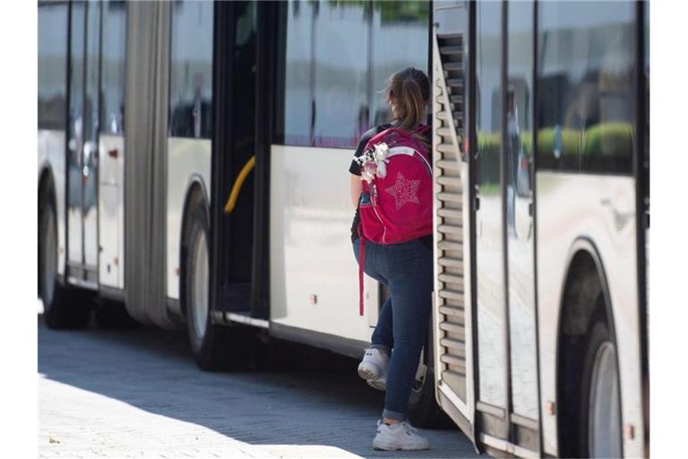 Eine Schülerin steigt an einer Bushaltestelle in einen Bus ein. Foto: Marijan Murat/dpa