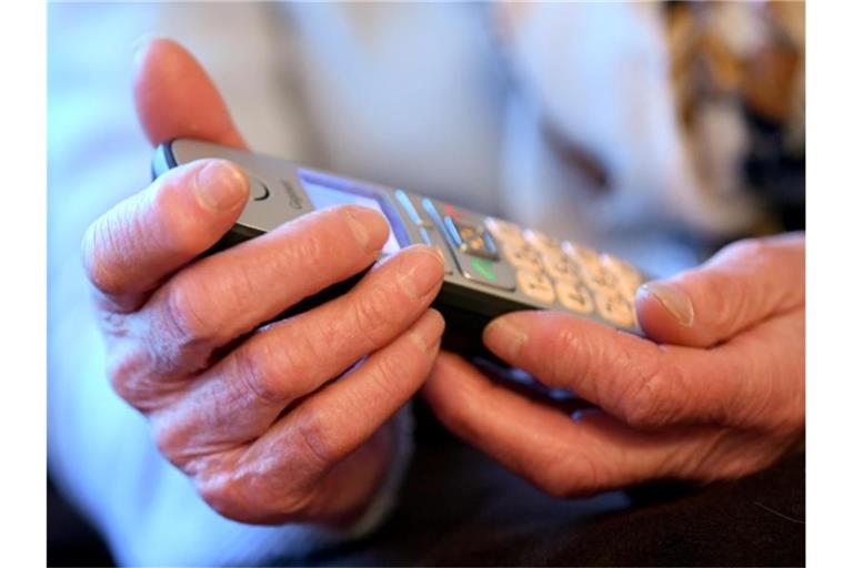 Eine Seniorin hält einen Telefonhörer in ihren Händen. Foto: Britta Pedersen/zb/dpa/Archivbild