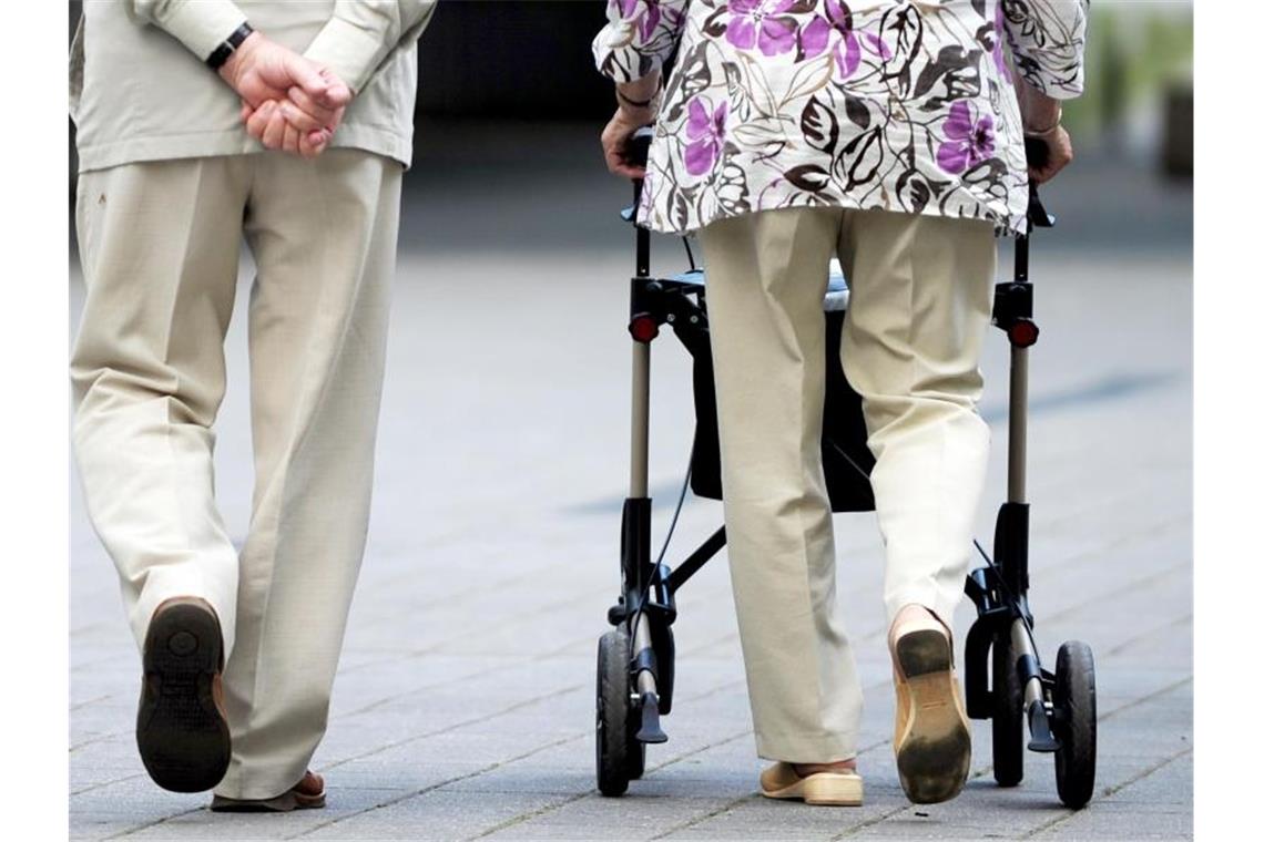 Eine Seniorin und ein Senior gehen gemeinsam spazieren. Foto: Federico Gambarini/dpa/dpa-tmn/Symbolbild