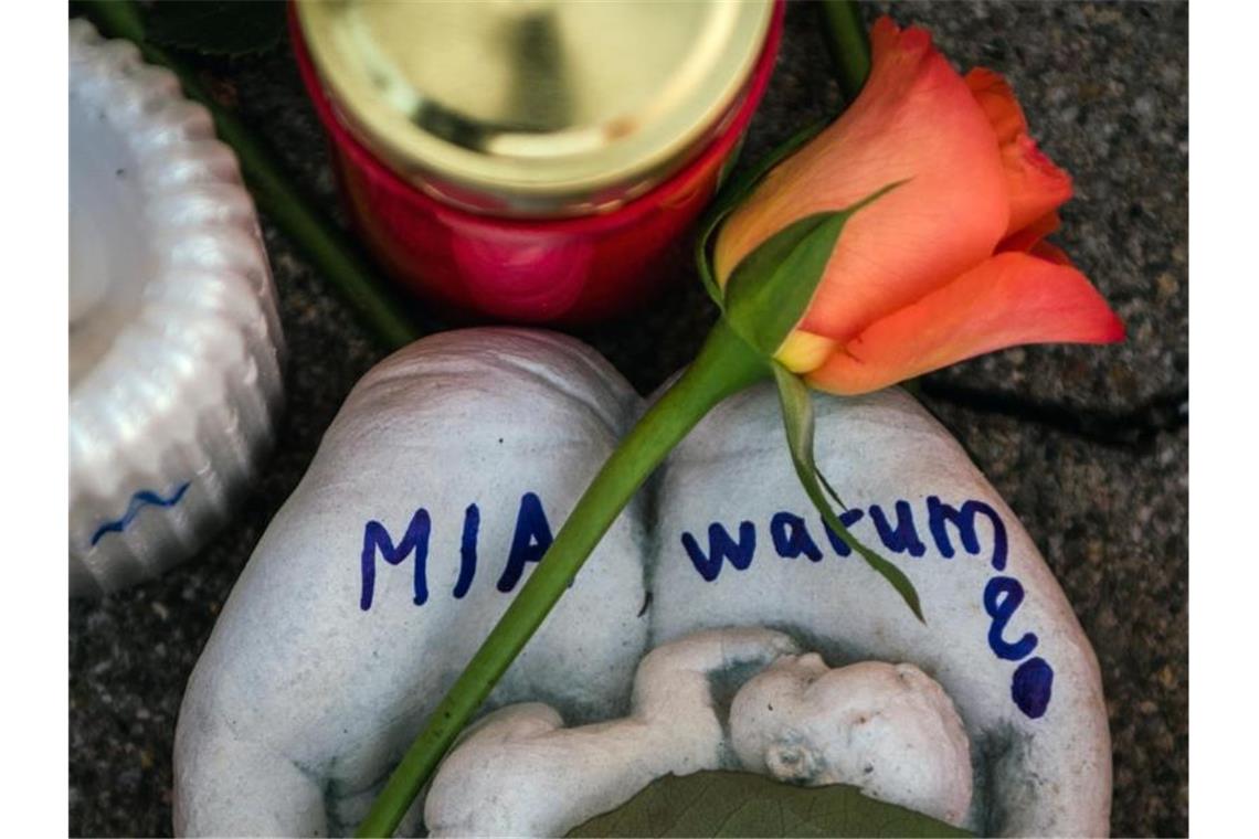 Eine Skulptur in Form zweier Handflächen mit der Aufschrift „Mia warum?“ und eine Rose liegen vor dem Drogeriemarkt, in die 15-jährige Mädchen von ihrem Ex-Freund erstochen wurde. Foto: Andreas Arnold/dpa