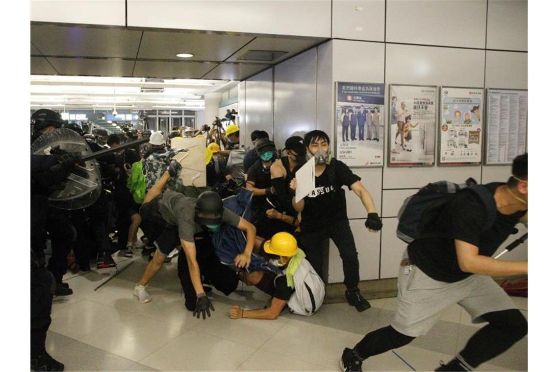 Eine Spezialeinheit der Polizei greift Demonstranten mit Schlagstöcken an, die sich weigern einen Bahnhof zu verlassen. Foto: Eric Tsang/HK01/AP