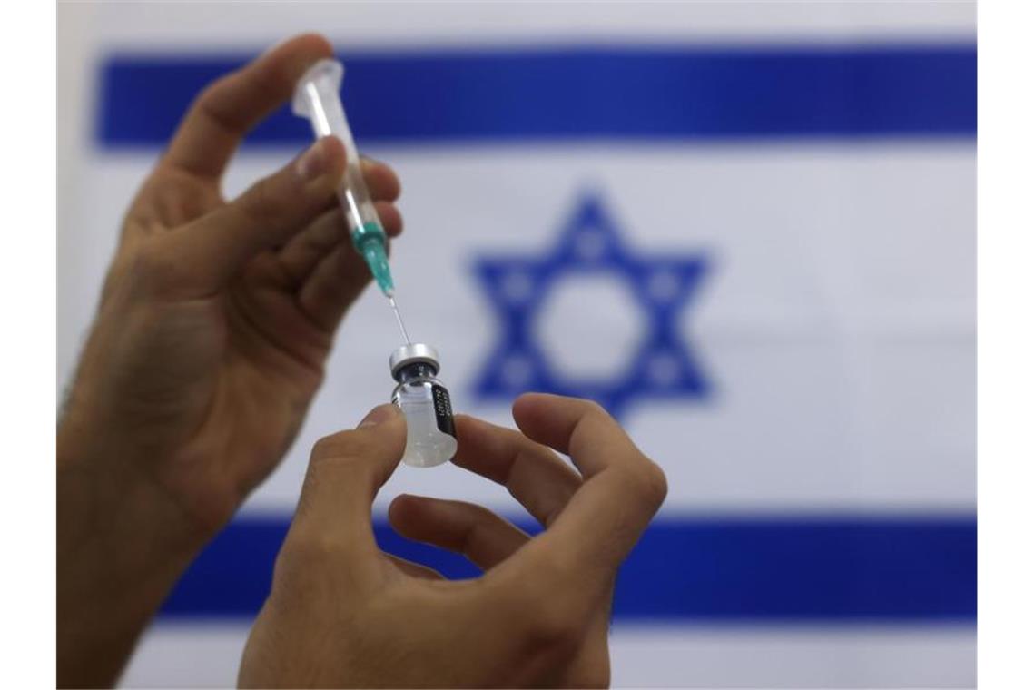 Eine Spritze wird mit dem Corona-Impfstoff von Biontech/Pfizer aufgezogen. Foto: Tsafrir Abayov/AP/dpa