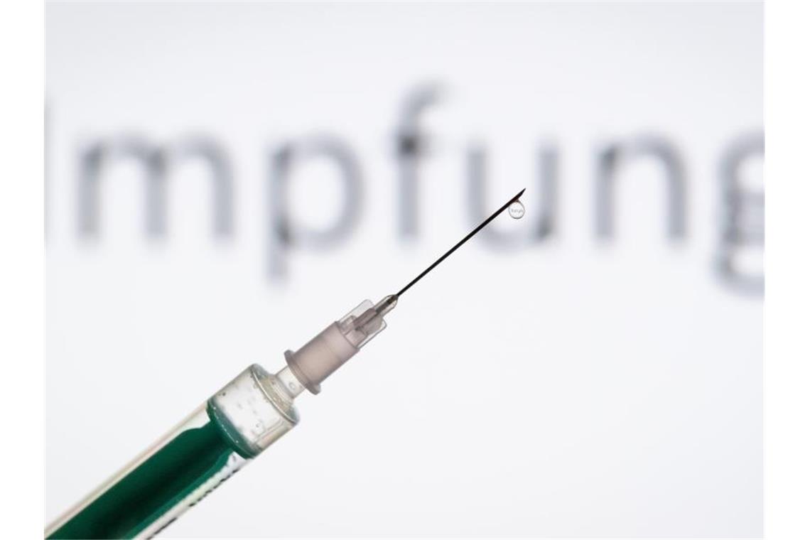Eine Spritze wird vor einen Schriftzug „Impfung“ gehalten. Foto: Friso Gentsch/dpa/Symbolbild