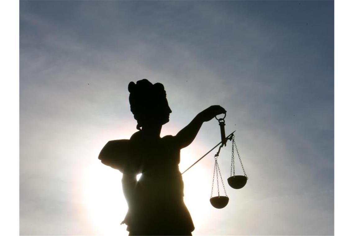 Geänderter Haftbefehl: Möglicher Anschlag auf Eisbahn Eine Statue der Justitia wird vom Gegenlicht angestrahlt und hält eine Waage in der Hand. Foto: Arne Dedert/dpa