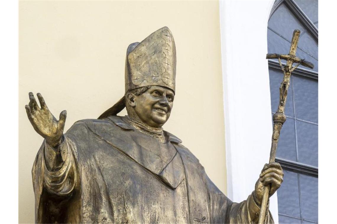 Eine Statue des emeritierten Papstes Benedikt XVI. am Kapellenplatz im Zentrum von Altötting. Foto: Peter Kneffel/dpa