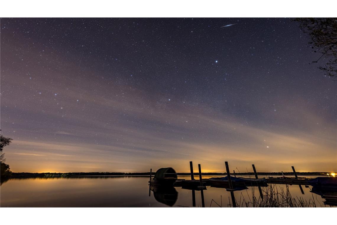 Eine Sternschnuppe der Lyriden ist am Nachthimmel über dem Spremberger Stausee in Brandenburg zu sehen.