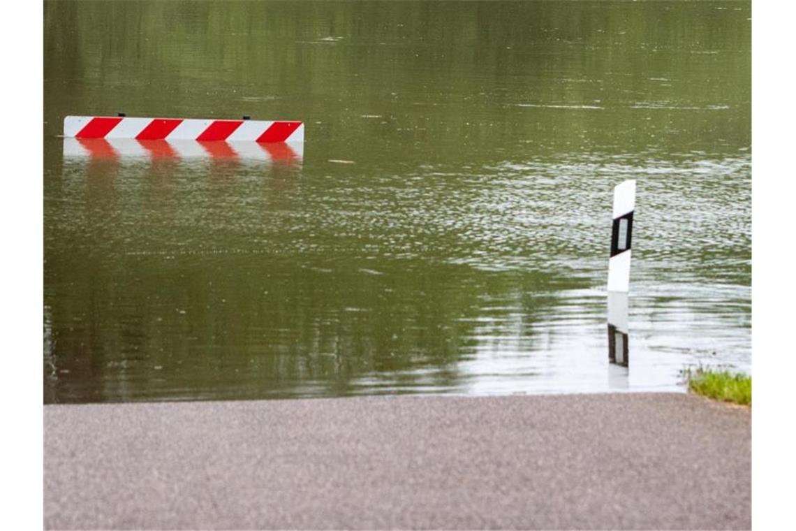 Eine Straße ist vom Hochwasser überflutet. Foto: Armin Weigel/dpa/Archivbild