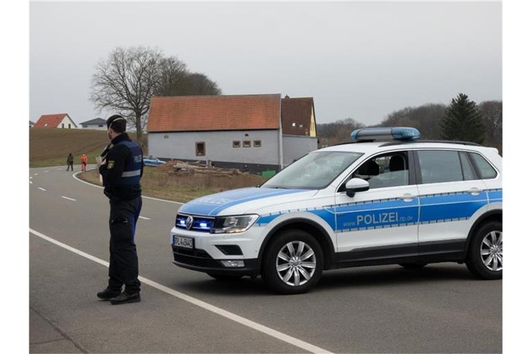 Eine Straße wird mit einem Einsatzfahrzeug der Polizei abgesperrt. Foto: Harald Tittel/dpa