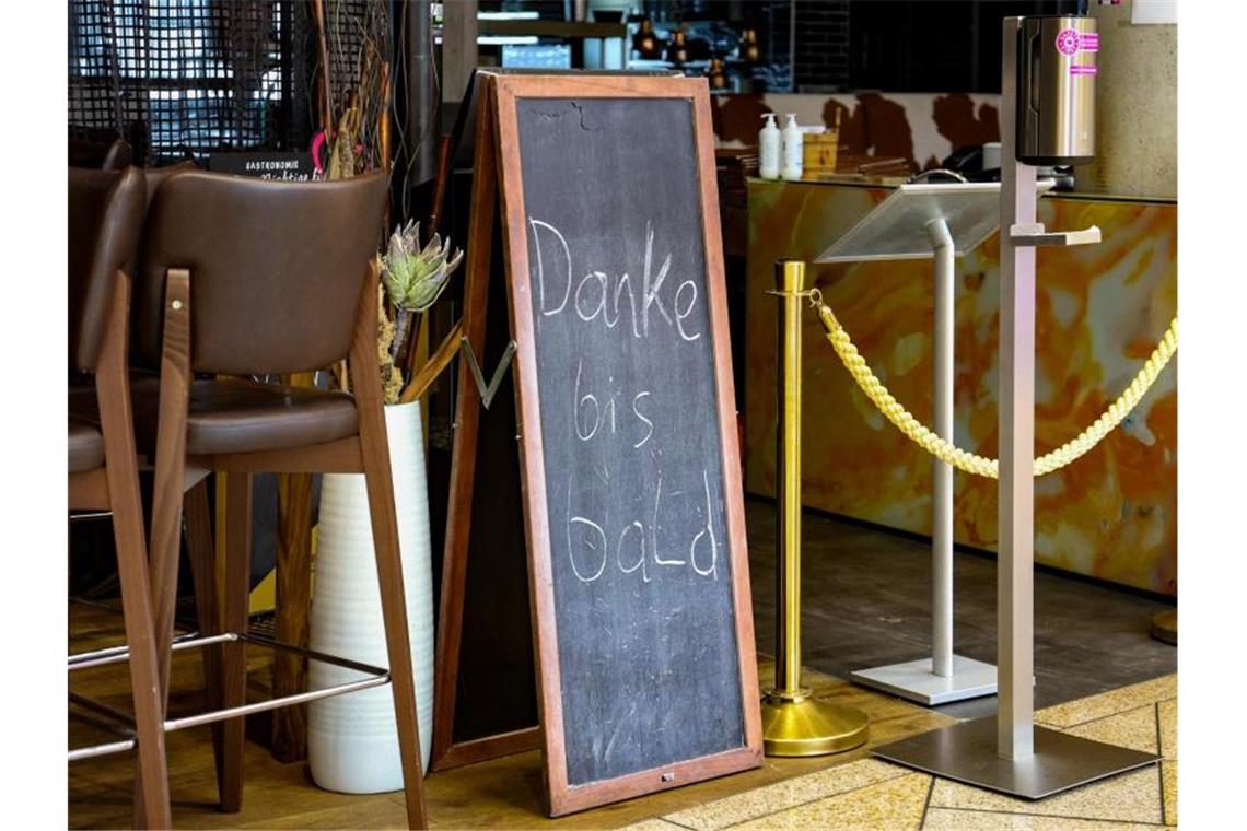 Eine Tafel mit der Aufschrift „Danke bis bald“ steht vor einem geschlossenen Gastronomiebetrieb im öberösterreichischen Pasching. Foto: Fotokerschi.At / Bayer/APA/dpa