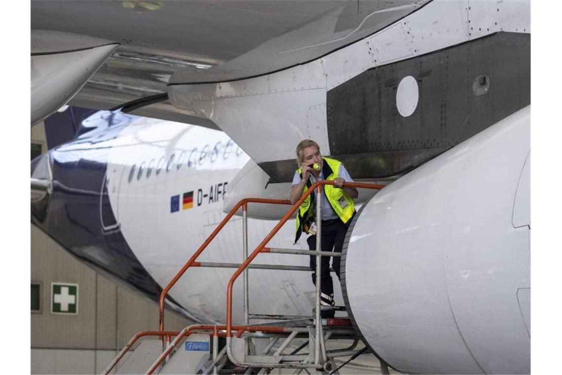 Eine Technikerin der Lufthansa inspiziert das Äußere einer Passagiermaschine der Lufthansa im Hangar der Airline auf dem Flughafen Frankfurt. Foto: Boris Roessler/dpa