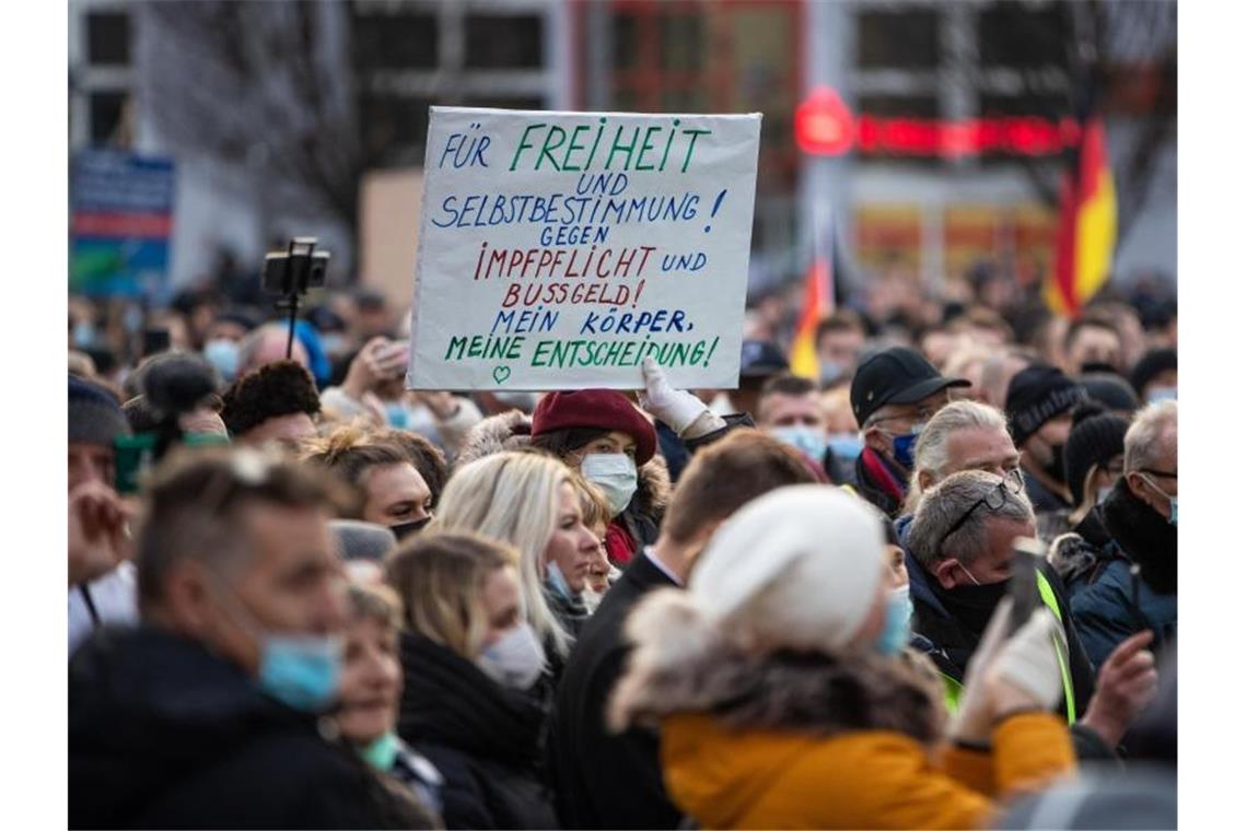 Mannheim, Ravensburg: Ausschreitungen bei Corona-Demos Eine Teilnehmerin einer Demonstration gegen die Corona-Maßnahmen hebt ein Transparent mit der Aufschrift "Für Freiheit und Selbstbestimmung! Gegen Impflicht und Bussgeld! Mein Körper, meine Entscheidung!" in die Höhe. Foto: Christoph Schmidt/dpa/Archivbild