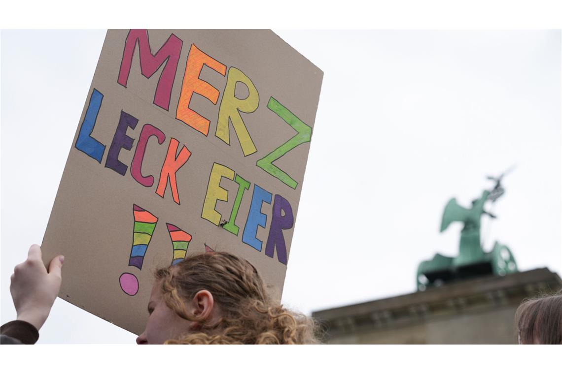 Eine Teilnehmerin einer Demonstration gegen die Wehrpflicht hält ein Plakat, auf dem steht „Merz leck Eier!!!“ (Archivfoto).