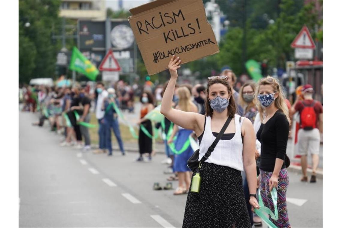 Eine Teilnehmerin in Berlin zeigt das Motto „Black Lives Matter“. Foto: Jörg Carstensen/dpa