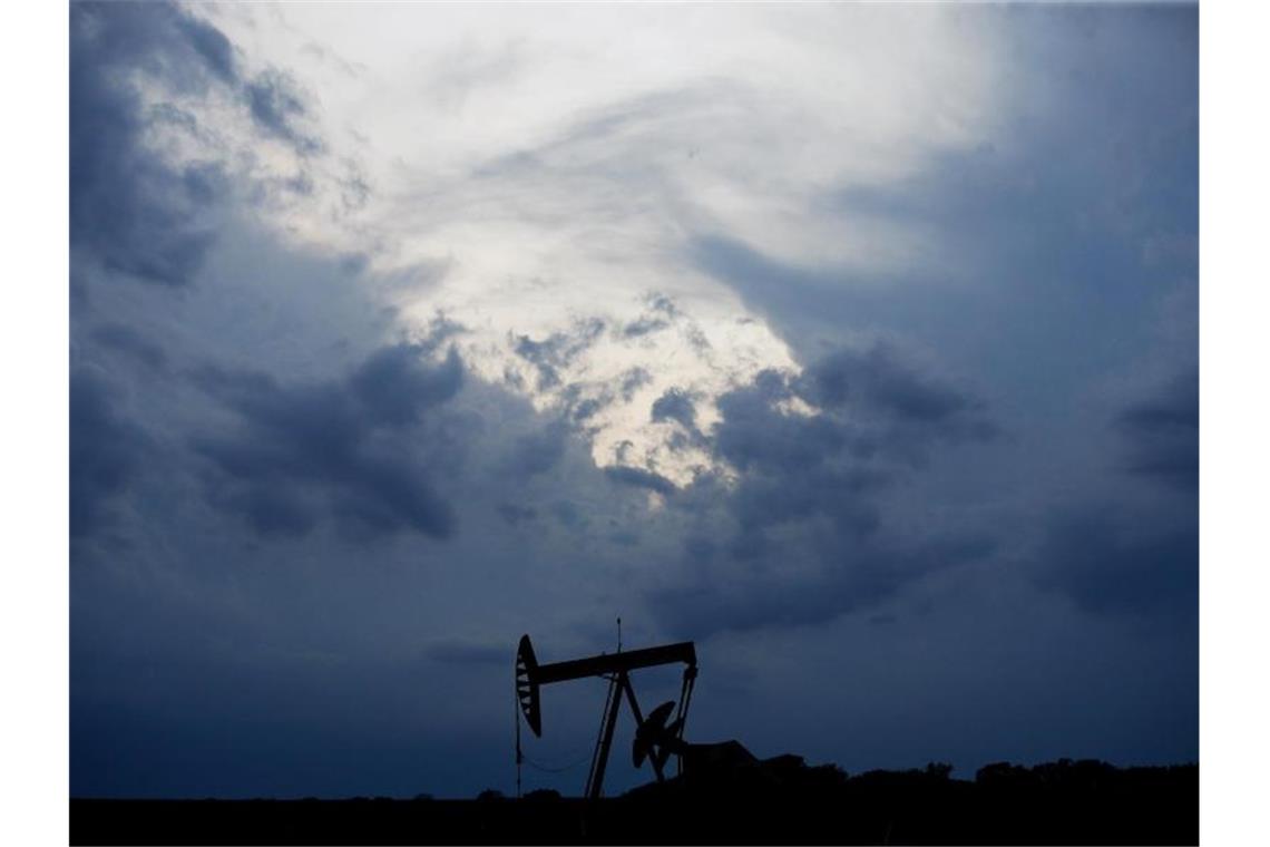 Eine Tiefpumpe arbeitet auf den Ölfeldern, während in Oklahoma City ein Sturm aufzieht. Foto: Sue Ogrocki/AP/dpa