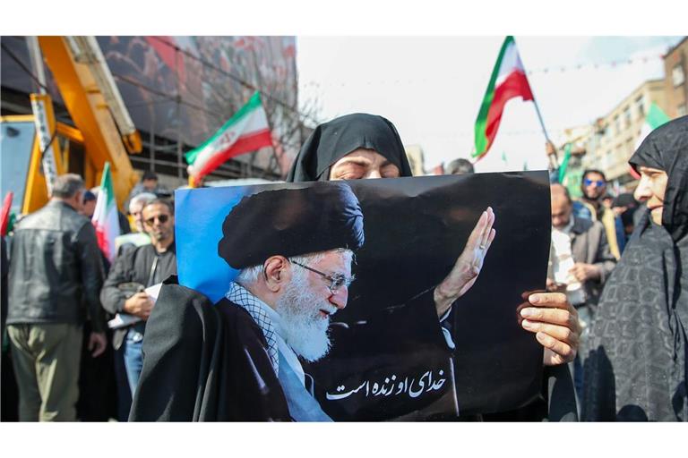 Eine Trauernde hält beim Begräbnis des von Israel getöteten Generalsekretärs des iranischen Sicherheitsrats, Ali Laridschani, ein Bild des ebenfalls getöteten Obersten Führers Ajatollah Ali Chamenei in die Höhe.