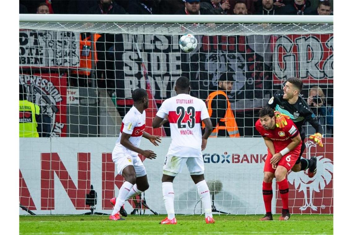 Eine unglückliche Faustabwehr von VfB-Keeper Fabian Bredlow (r) brachte Leverkusen auf Kurs Viertelfinale. Foto: Guido Kirchner/dpa