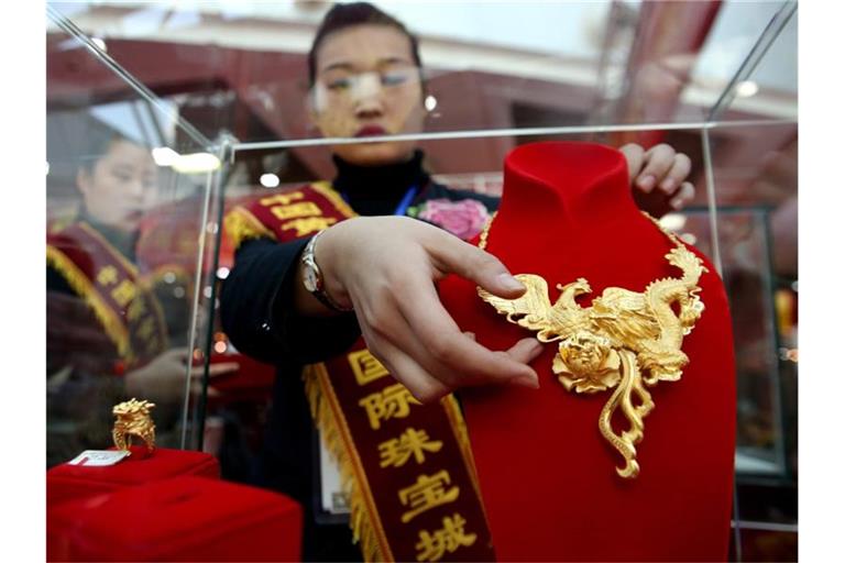 Eine Verkäuferin im chinesischen Shenyang bei der Präsentation von Goldschmuck. Foto: Wu Hong/epa
