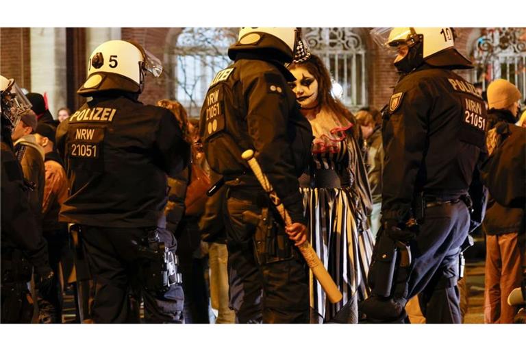 Eine verkleidete Demonstrantin wird von Polizeibeamten befragt. Die Initiative „Gen Z regelt“ hatte für den 31. Oktober zu Protesten in rund 30 Städten aufgerufen.