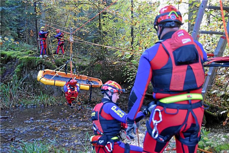 Eine von 13 Stationen bei der Übung: Im Fischbachtal steht eine Wasserrettung an. Zum Überbrücken des Bachs verwenden die DLRG-Helfer eine Korbtrage. Fotos: Tobias Sellmaier