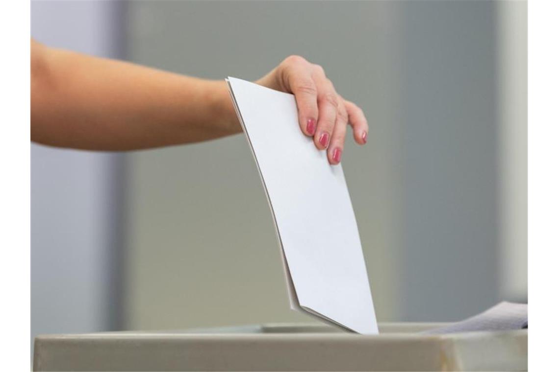 Eine Wählerin wirft bei der Stimmabgabe zur Landtagswahl in Sachsen ihren Wahlzettel in eine Wahlurne. Foto: Robert Michael