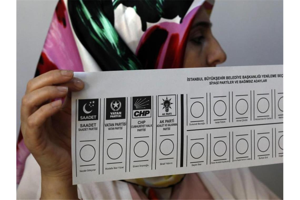 Eine Wahlhelferin hält in einem Wahllokal in Istanbul einen Stimmzettel in der Hand. Foto: Burhan Ozbilici/AP