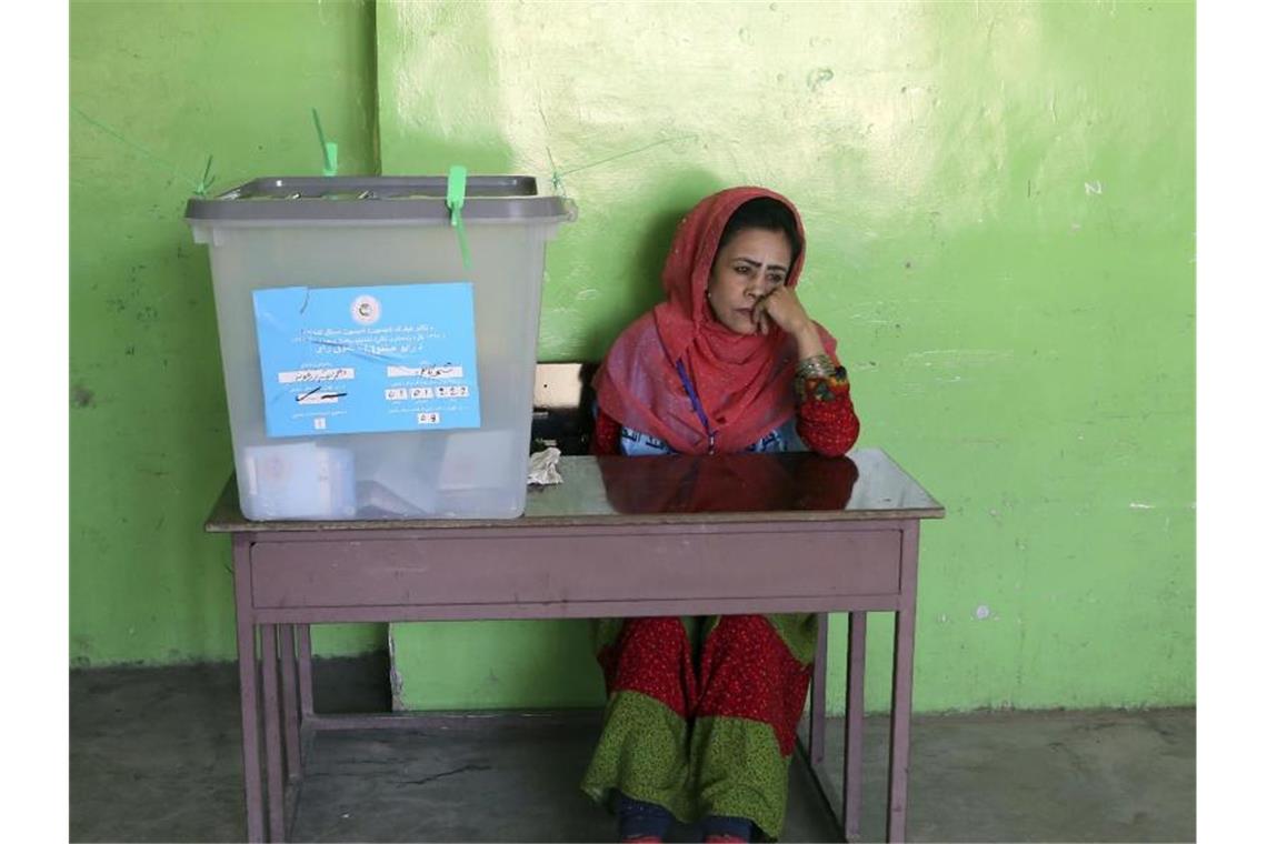 Eine Wahlhelferin sitzt in einem Wahllokal in Kabul neben einer Wahlurne. Foto: Rahmat Gul/AP