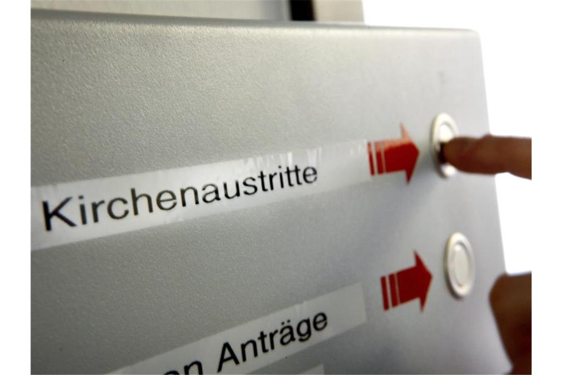 Entfremdung: Immer mehr Menschen treten aus der Kirche aus Eine Wartenummer für den Antrag auf den Austritt aus der Kirche drückt eine Frau beim Amtsgericht Köln. Foto: Oliver Berg