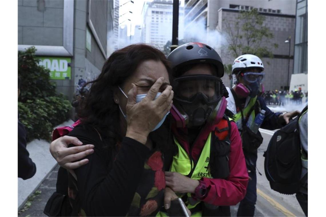 Hongkongs Polizei stoppt Marsch von Zehntausenden mit Gewalt Eine weinende Demonstrantin wird an den Straßenrand geführt. Foto: Ng Han Guan/AP/dpa