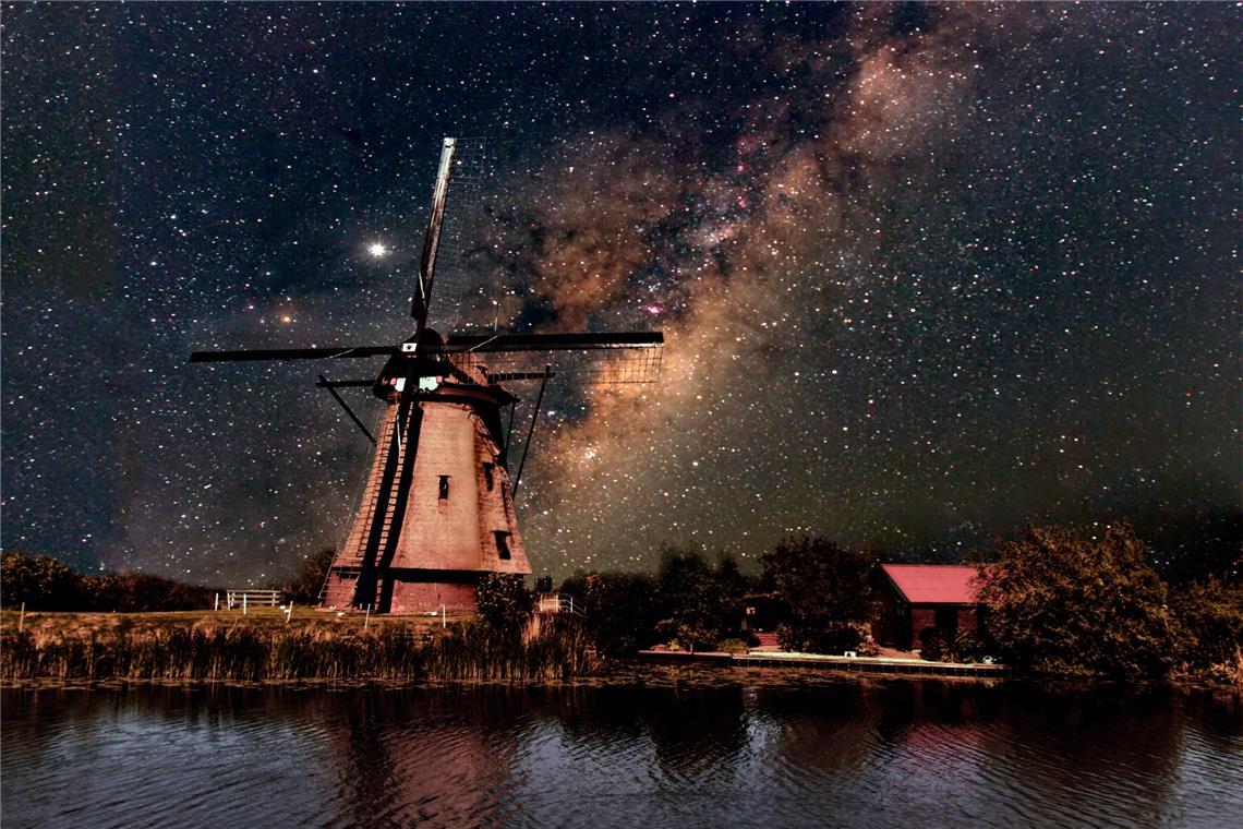 Woher kommt der Mensch? Eine Spurensuche im Kosmos Eine Windmühle vor der Silhouette der Milchstraße.