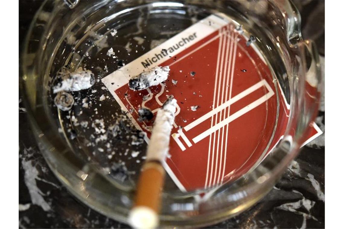 Kampf dem Qualmen: Preiserhöhungen für Zigaretten gefordert Eine Zigarette verglimmt in einem Aschenbecher. Foto: Helmut Fohringer/APA/dpa/Archivbild
