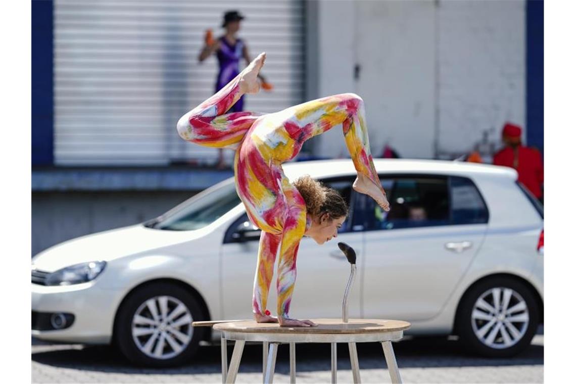 Eine Zirkuskünstlerin zeigt Kunststücke bei einem Zirkus-Drive-In. Foto: Uwe Anspach/dpa