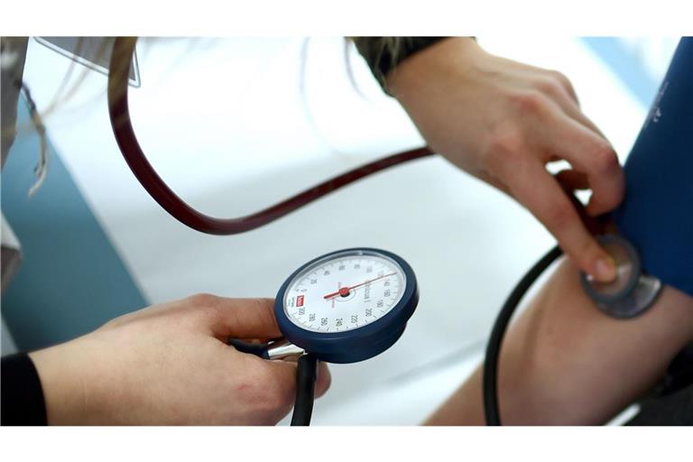 Einem Patienten wird in einer Arztpraxis der Bluthochdruck gemessen.