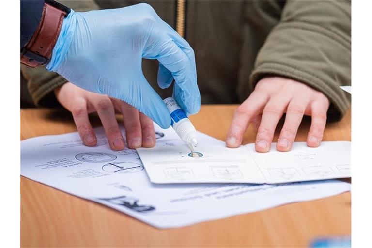 Einem Schulkind in Wien wird die Handhabung eines Antigen-Schnelltests gezeigt. Foto: Georg Hochmuth/APA/dpa