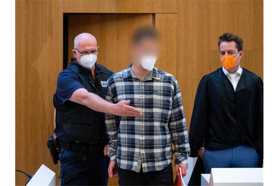 Einer der beiden wegen Mordes angeklagten Männer (M) wird in den Sitzungssaal geführt. Foto: Sven Hoppe/dpa
