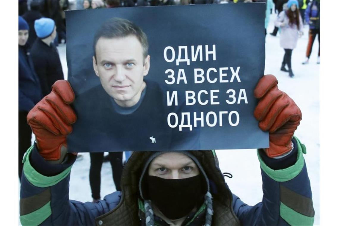 „Einer für alle und alle für einen“: Ein Demonstrant in St. Petersburg mit einem Plakat, auf dem das Konterfei von Alexej Nawalny zu sehen ist. Foto: Dmitri Lovetsky/AP/dpa