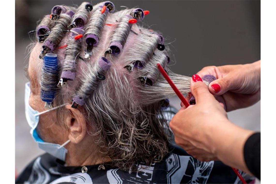 Einer Kundin werden in einem Friseursalon die Haare frisiert. Auch Überbrückungshilfen hatten die hohen Einnahmeeinbußen bei Klier besonders während des Shutdowns im Frühjahr nicht ausgleichen können. Foto: Jens Büttner/dpa-Zentralbild/dpa