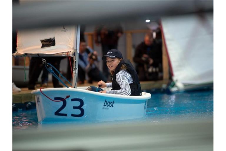 Eines der etwas kleineren Modelle: Model Mia in einem „Optimist“ bei der Wassersportmesse „Boot 2020“. Foto: Federico Gambarini/dpa