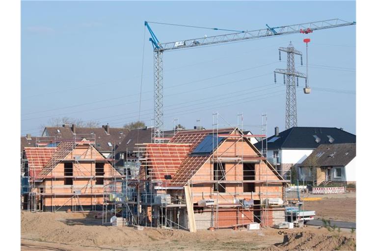 Einfamilienhäuser stehen im Rohbau in einem Neubaugebiet in der Region Hannover. Foto: Julian Stratenschulte/dpa