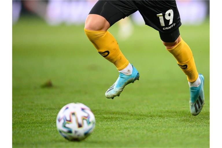 Ein Fußballspieler spielt den Ball. Foto: Robert Michael/dpa-Zentralbild/dpa/Symbolbild