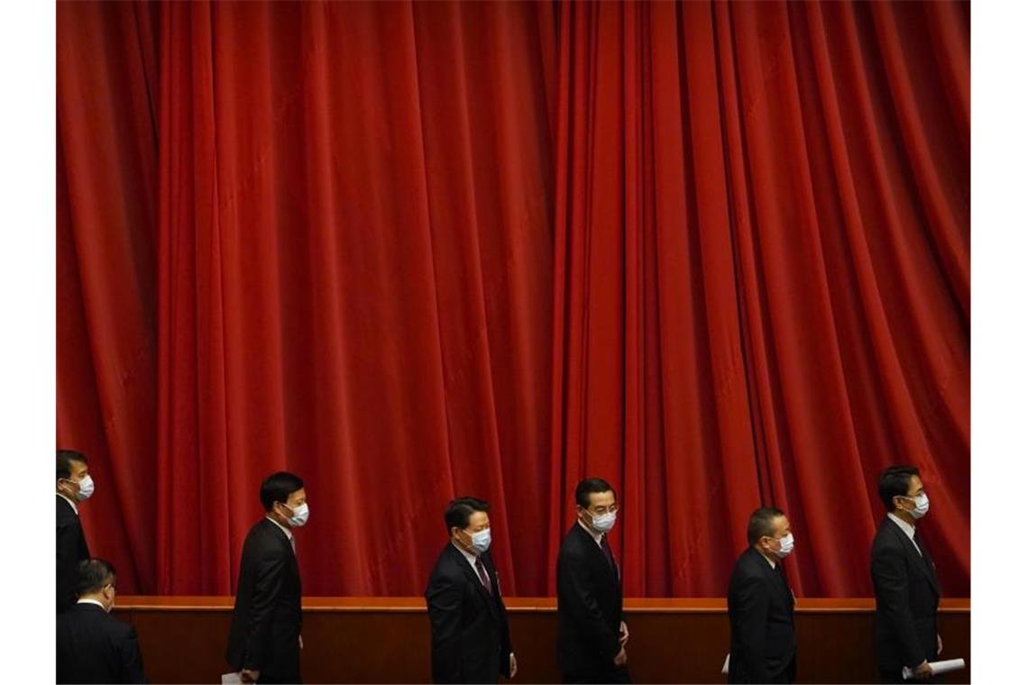 China schränkt Demokratie in Hongkong weiter ein Einige der knapp 300 Delegierten verlassen nach der Abschlusssitzung des Volkskongresses die Große Halle des Volkes. Foto: Mark Schiefelbein/AP/dpa