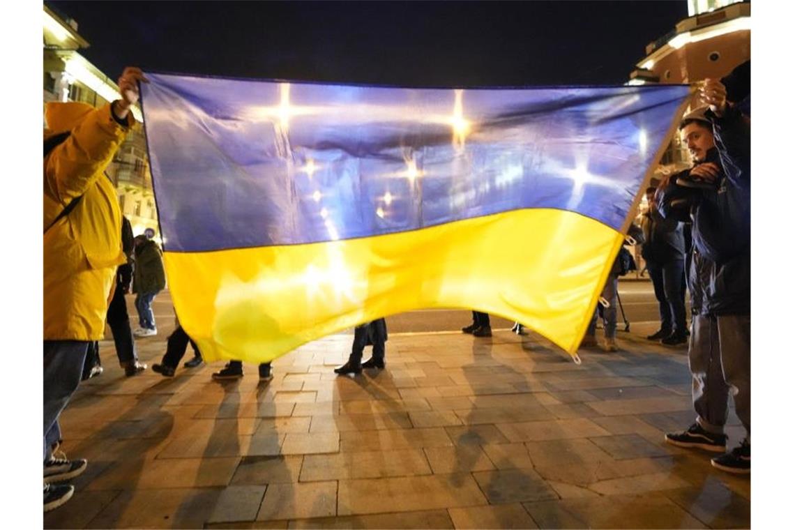 Warnung vor „Kettenreaktion“ bei Atombewaffnung Irans Einige Menschen halten im Rahmen der patriotischen Aktion „Mariupol ist die Ukraine“ eine große Fahne. Foto: Sergei Grits/AP/dpa
